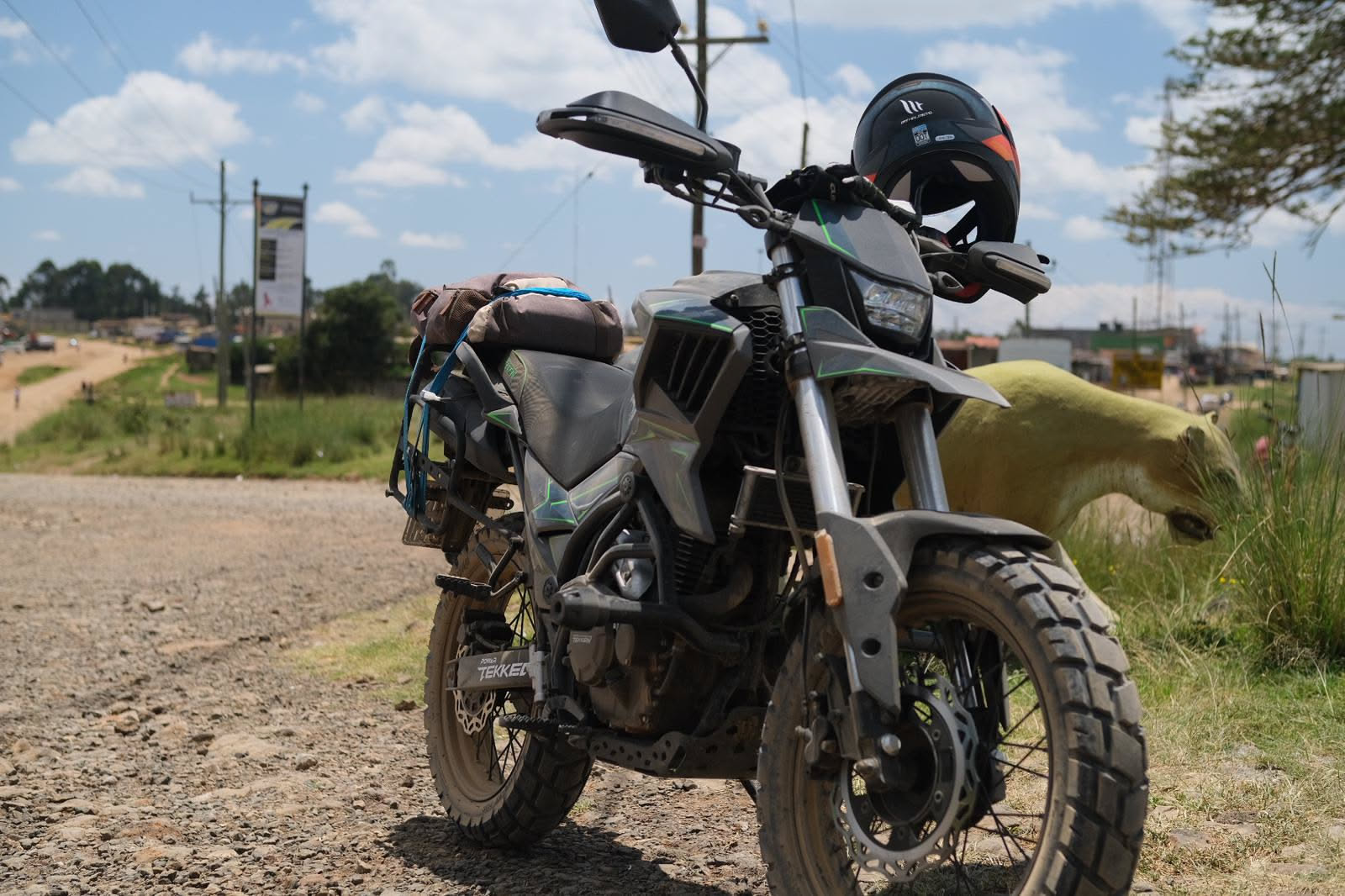 Moto de la flota RAFIKI preparada y equipada junto a una carretera de tierra en Kenya